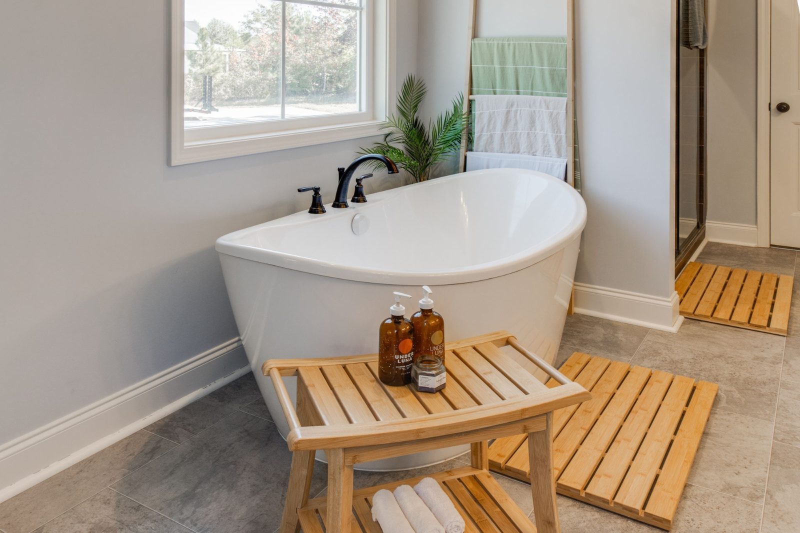 Spa-inspired bathroom with freestanding soaking tub, natural stone, and warm lighting
